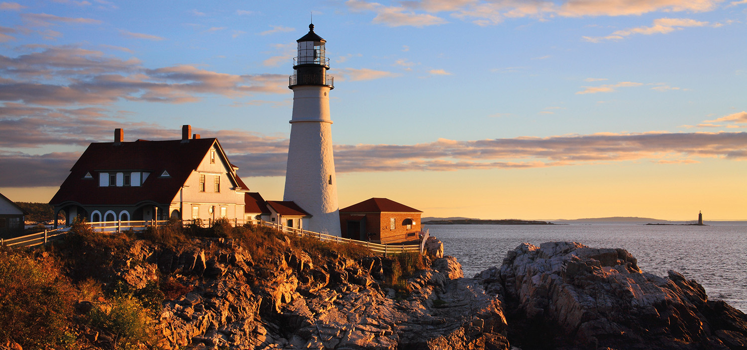 New England yacht charter lighthouse and craggy coastline